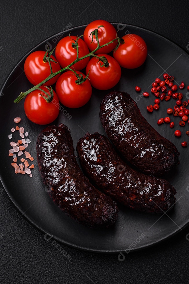 Delicioso chouriço preto ou morcela com especiarias e ervas grelhadas sobre fundo de concreto preto