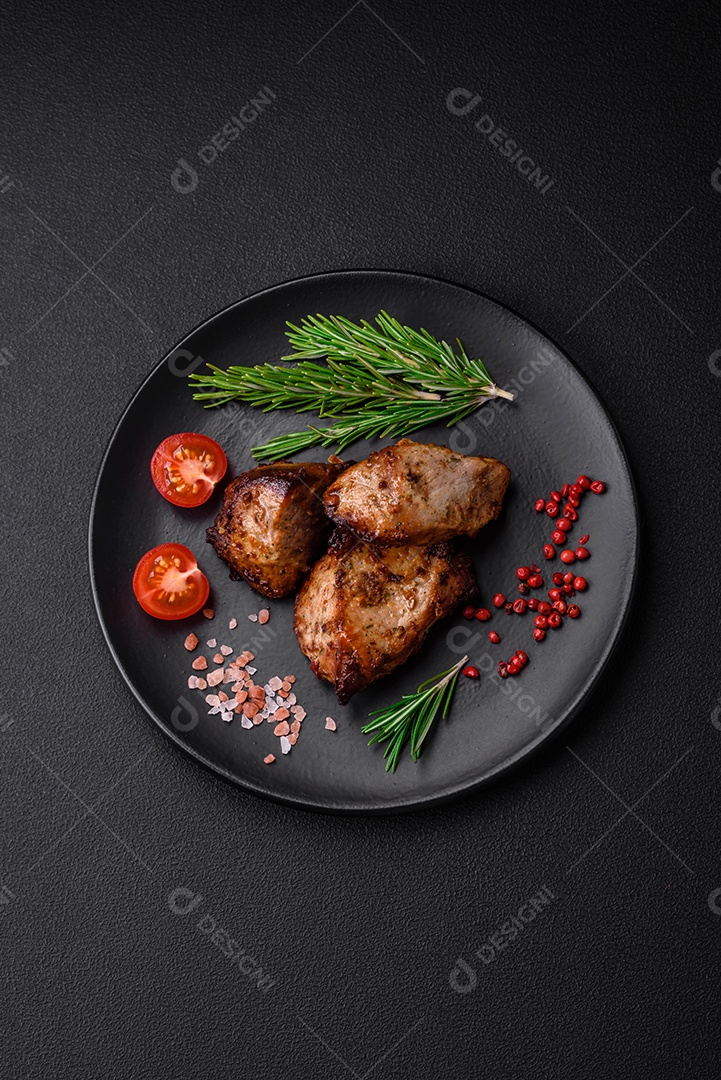 Deliciosas fatias de batata grelhada com alho, especiarias e ervas sobre um fundo escuro de concreto