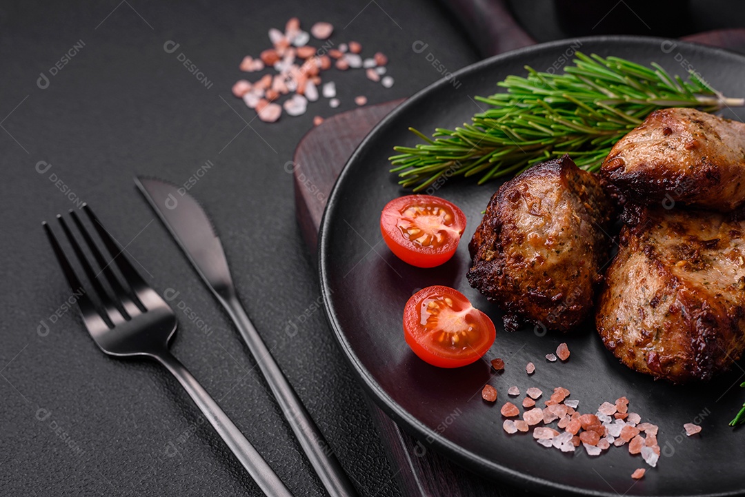 Deliciosa carne grelhada em forma de kebab com especiarias e ervas sobre um fundo escuro de concreto