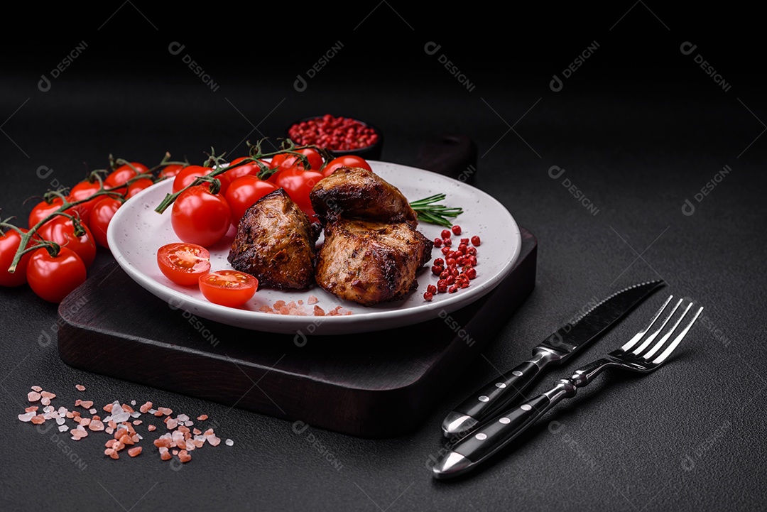 Deliciosas fatias de batata grelhada com alho, especiarias e ervas sobre um fundo escuro de concreto