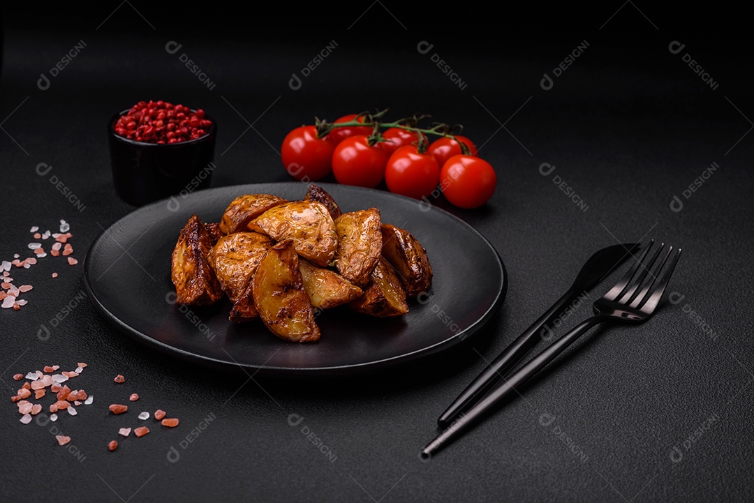 Deliciosas fatias de batata grelhada com alho, especiarias e ervas sobre um fundo escuro de concreto