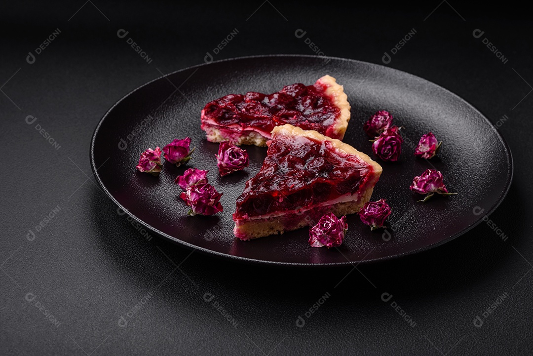Deliciosa torta doce perfumada com bagas de cereja em uma placa de cerâmica sobre um fundo escuro de concreto