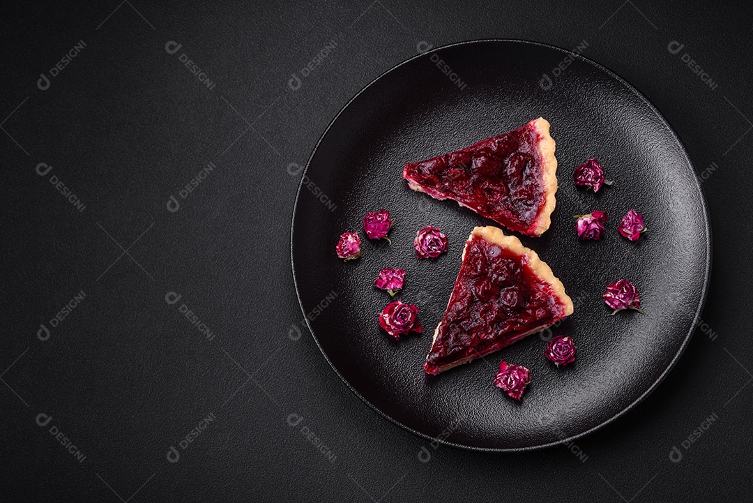Deliciosa torta doce perfumada com bagas de cereja em uma placa de cerâmica sobre um fundo escuro de concreto