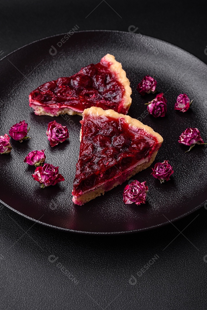 Deliciosa torta doce perfumada com bagas de cereja em uma placa de cerâmica sobre um fundo escuro de concreto