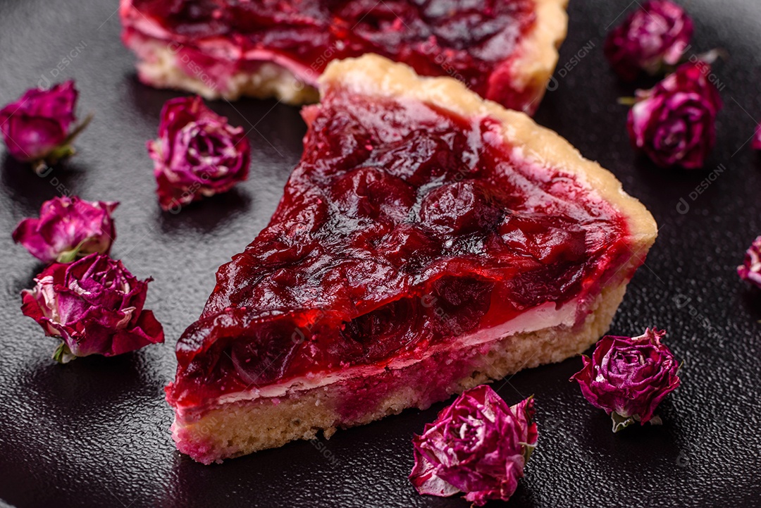 Deliciosa torta doce perfumada com bagas de cereja em uma placa de cerâmica sobre um fundo escuro de concreto