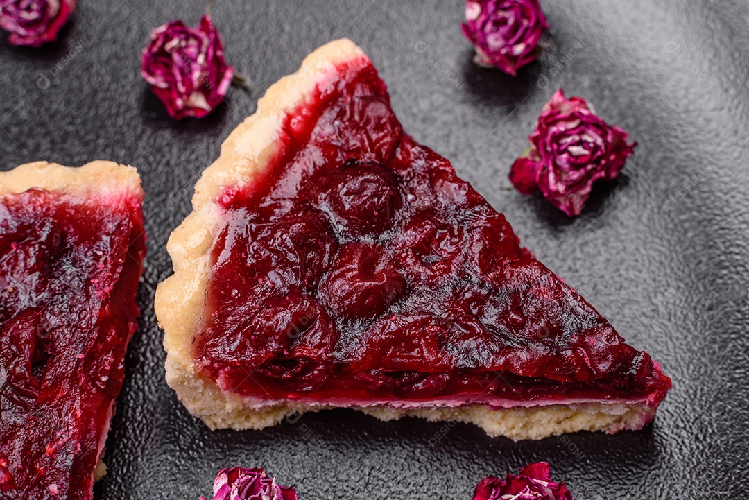 Deliciosa torta doce perfumada com bagas de cereja em uma placa de cerâmica sobre um fundo escuro de concreto