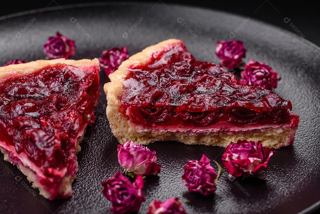 Deliciosa torta doce perfumada com bagas de cereja em uma placa de cerâmica sobre um fundo escuro de concreto