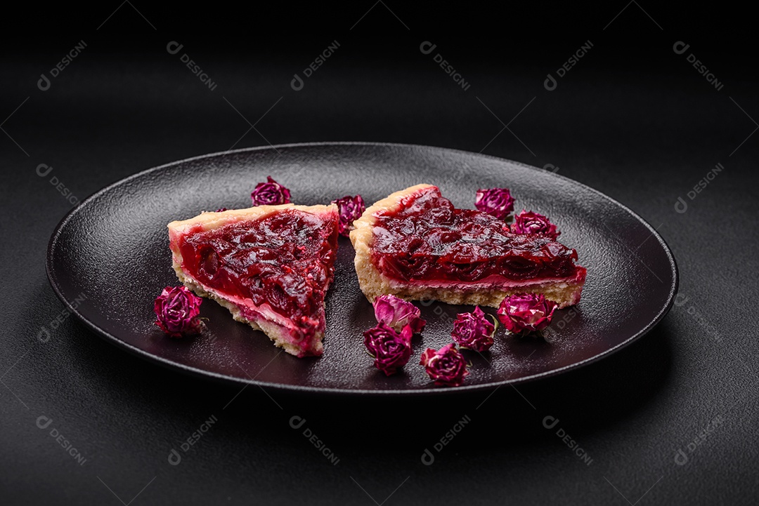 Deliciosa torta doce perfumada com bagas de cereja em uma placa de cerâmica sobre um fundo escuro de concreto