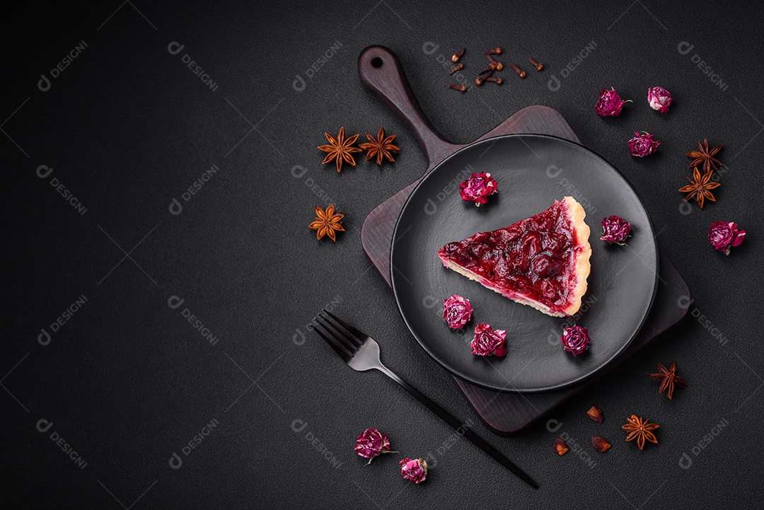 Deliciosa torta doce perfumada com bagas de cereja em uma placa de cerâmica sobre um fundo escuro de concreto