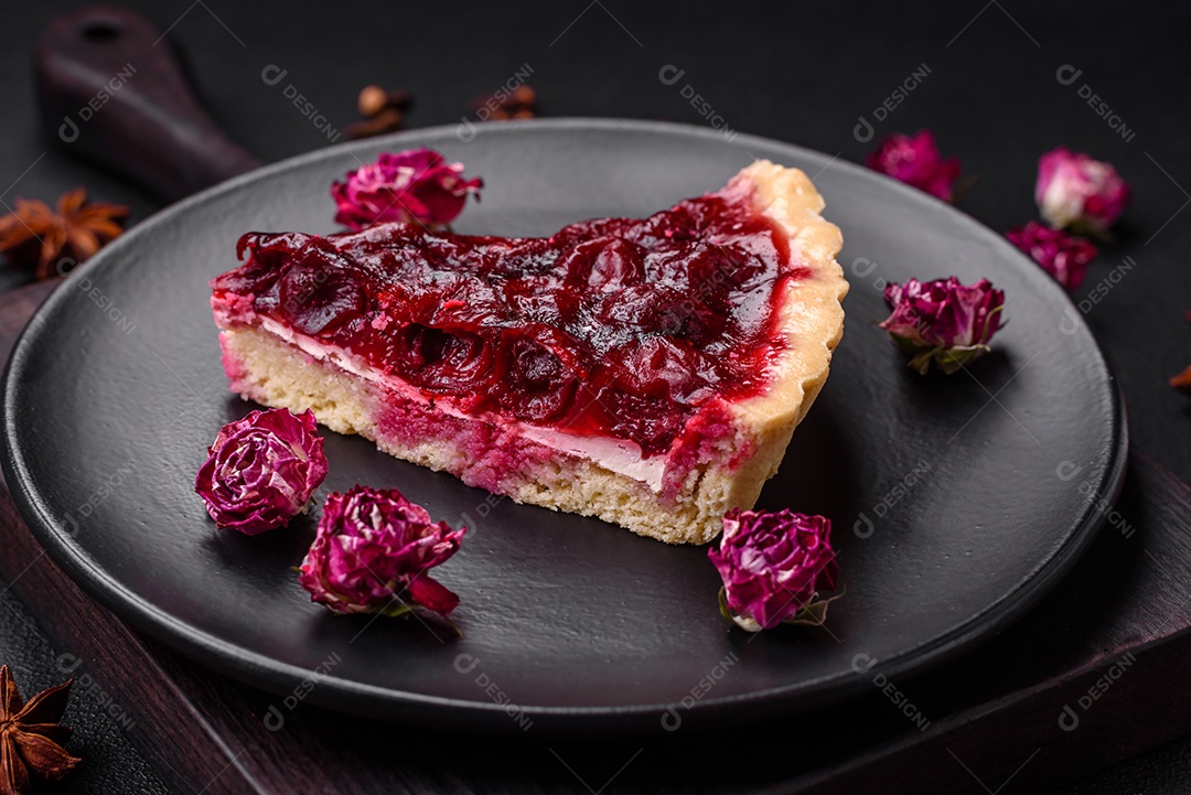 Deliciosa torta doce perfumada com bagas de cereja em uma placa de cerâmica sobre um fundo escuro de concreto