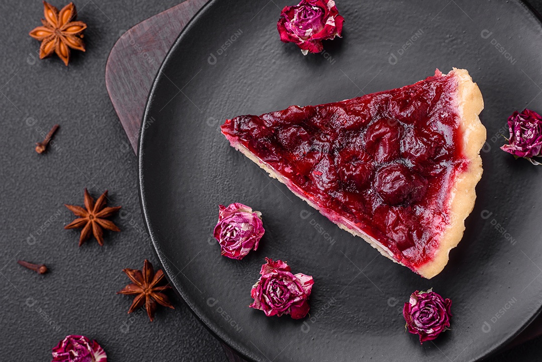 Deliciosa torta doce perfumada com bagas de cereja em uma placa de cerâmica sobre um fundo escuro de concreto