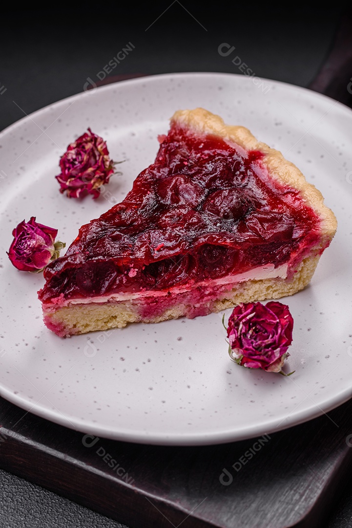 Deliciosa torta doce perfumada com bagas de cereja em uma placa de cerâmica sobre um fundo escuro de concreto