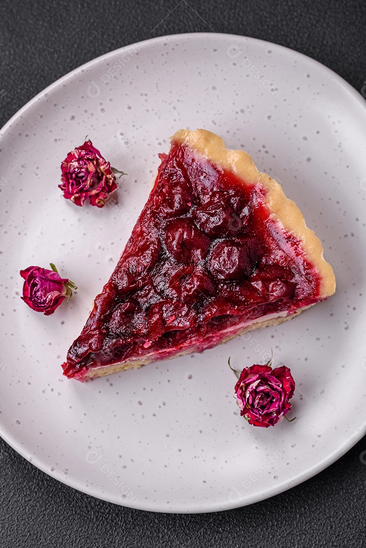 Deliciosa torta doce perfumada com bagas de cereja em uma placa de cerâmica sobre um fundo escuro de concreto