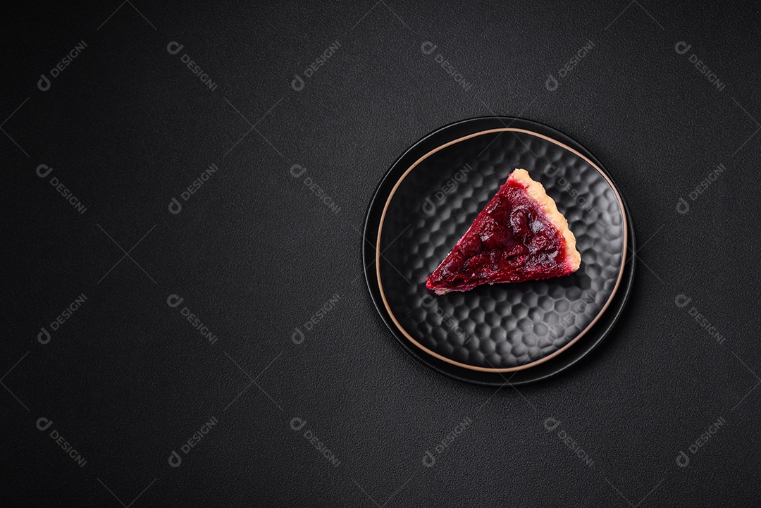 Deliciosa torta doce perfumada com bagas de cereja em uma placa de cerâmica sobre um fundo escuro de concreto