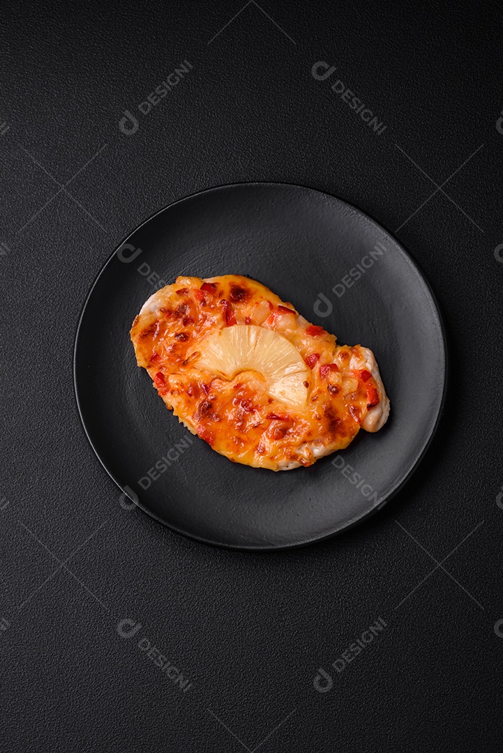 Filé de frango grelhado em forma de bife com tomate, abacaxi e queijo sobre fundo escuro de concreto