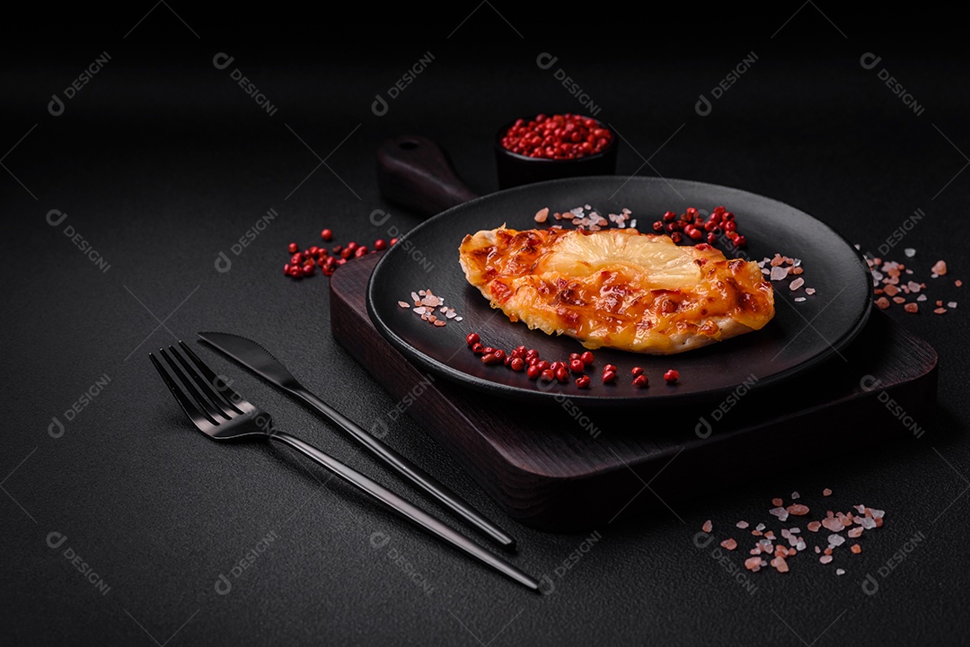 Filé de frango grelhado em forma de bife com tomate, abacaxi e queijo sobre fundo escuro de concreto