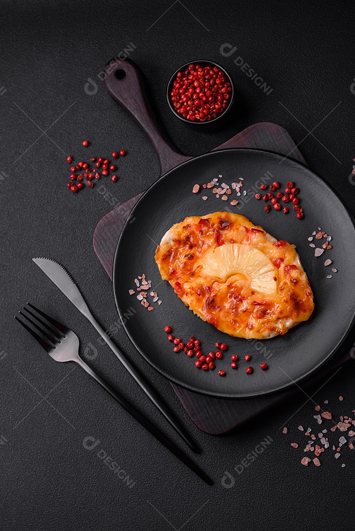 Filé de frango grelhado em forma de bife com tomate, abacaxi e queijo sobre fundo escuro de concreto