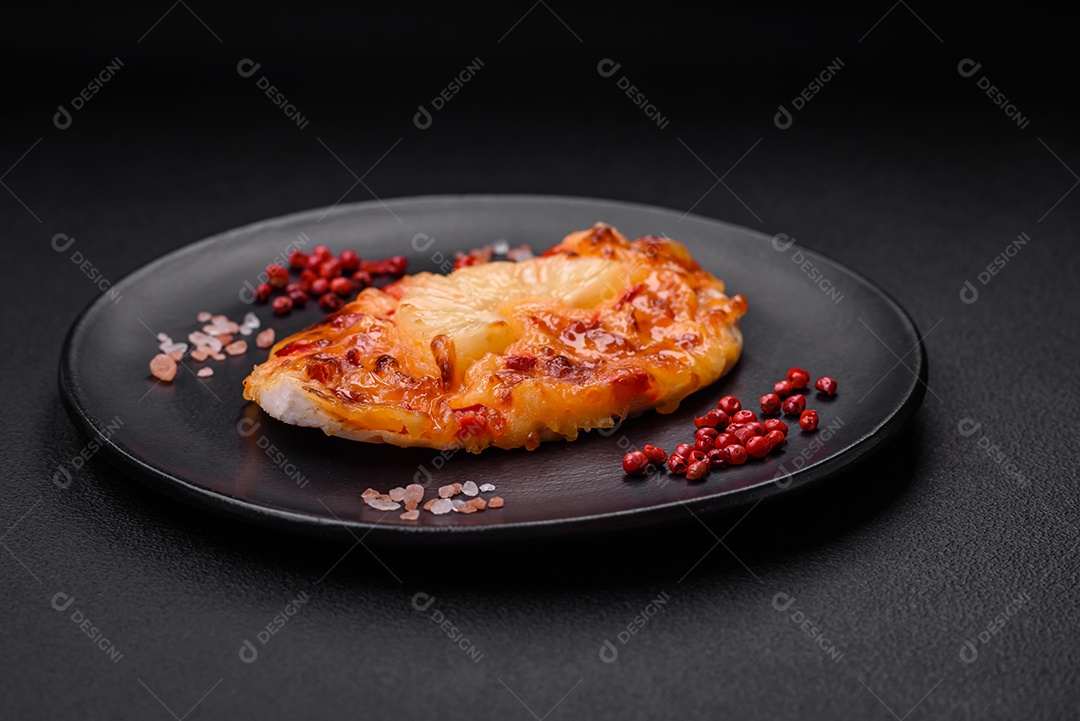 Filé de frango grelhado em forma de bife com tomate, abacaxi e queijo sobre fundo escuro de concreto