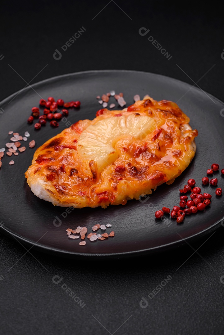 Filé de frango grelhado em forma de bife com tomate, abacaxi e queijo sobre fundo escuro de concreto