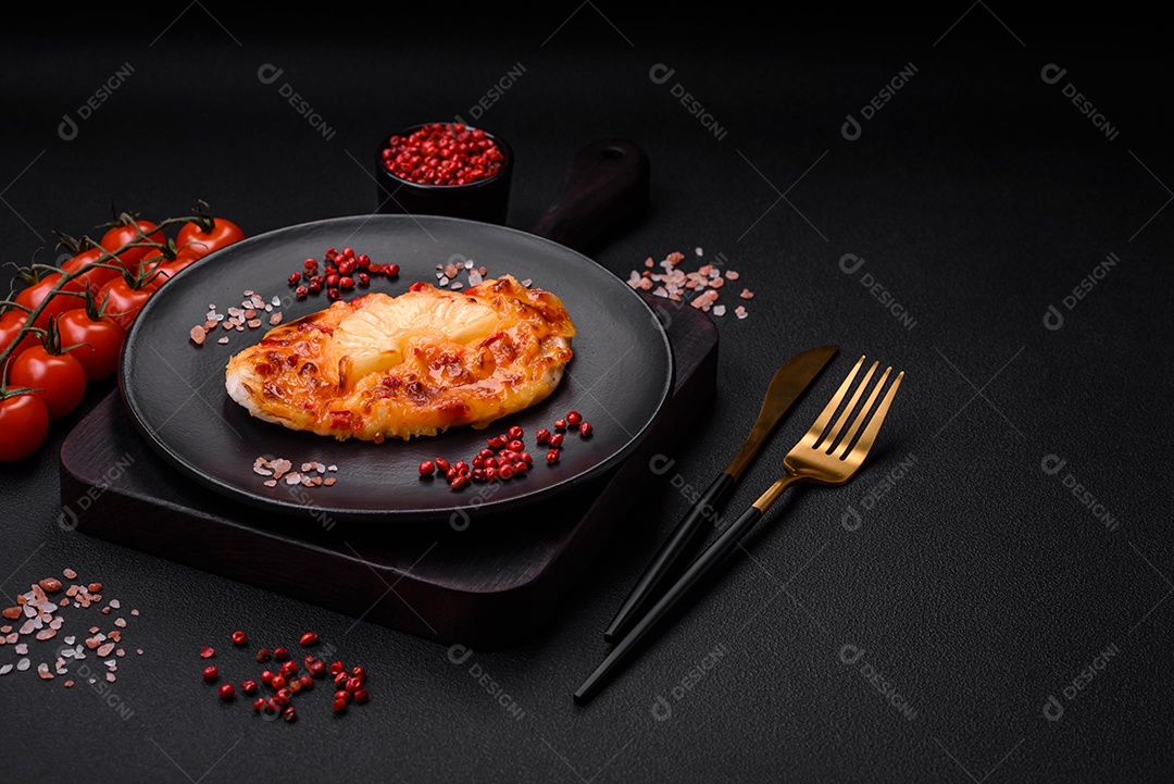 Filé de frango grelhado em forma de bife com tomate, abacaxi e queijo sobre fundo escuro de concreto