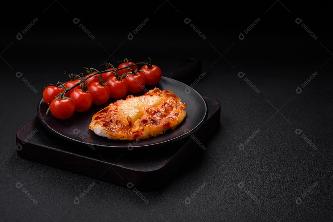 Filé de frango grelhado em forma de bife com tomate, abacaxi e queijo sobre fundo escuro de concreto