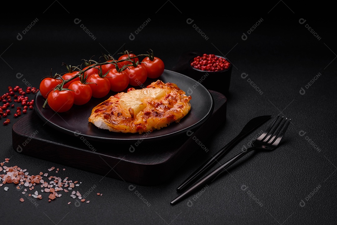 Filé de frango grelhado em forma de bife com tomate, abacaxi e queijo sobre fundo escuro de concreto