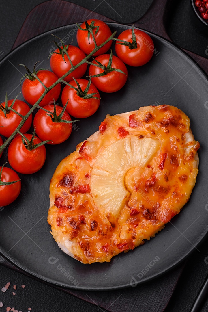 Filé de frango grelhado em forma de bife com tomate, abacaxi e queijo sobre fundo escuro de concreto