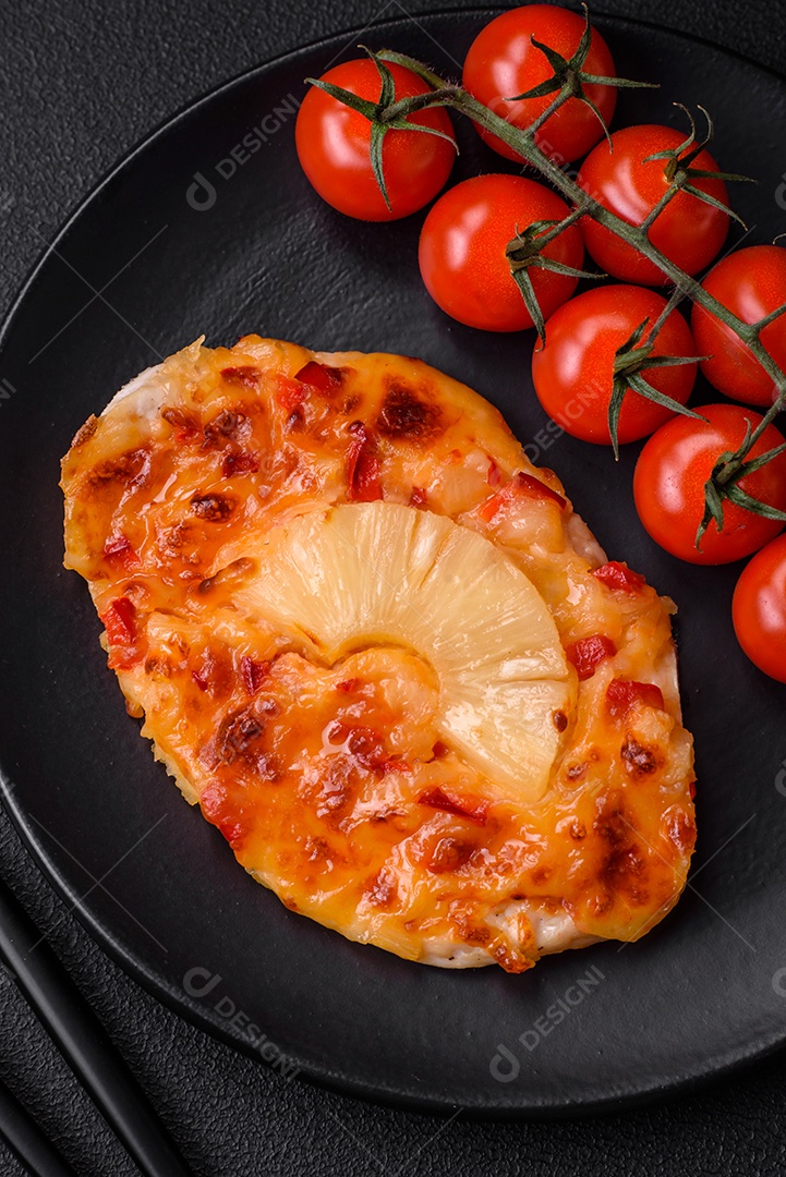 Filé de frango grelhado em forma de bife com tomate, abacaxi e queijo sobre fundo escuro de concreto