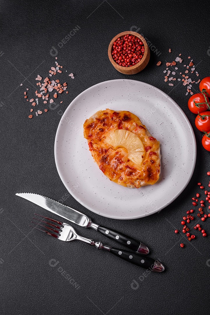 Filé de frango grelhado em forma de bife com tomate, abacaxi e queijo sobre fundo escuro de concreto