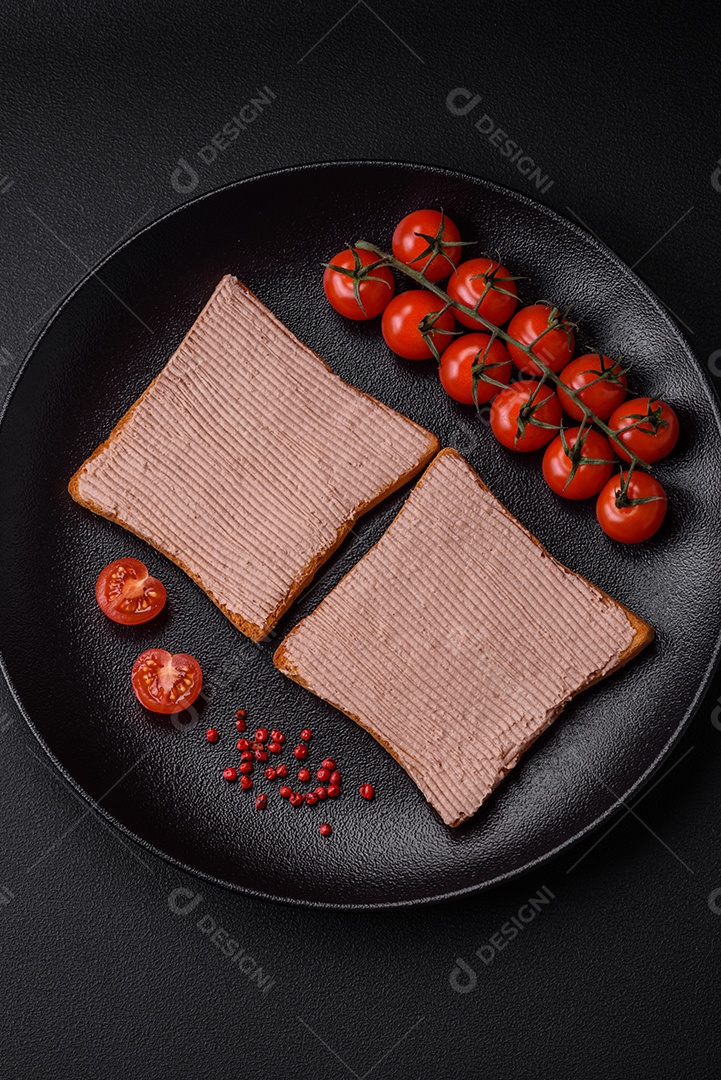 Deliciosa torrada crocante com frango ou patê de ganso com sal e especiarias sobre um fundo escuro de concreto