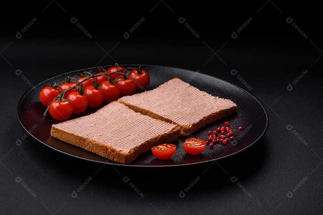 Deliciosa torrada crocante com frango ou patê de ganso com sal e especiarias sobre um fundo escuro de concreto