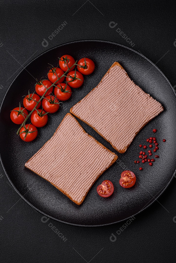 Deliciosa torrada crocante com frango ou patê de ganso com sal e especiarias sobre um fundo escuro de concreto