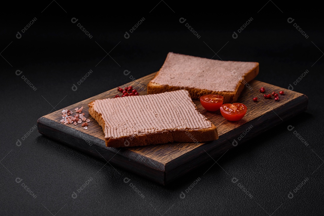 Deliciosa torrada crocante com frango ou patê de ganso com sal e especiarias sobre um fundo escuro de concreto