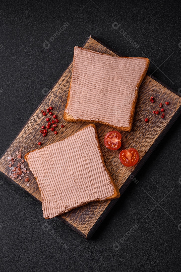 Deliciosa torrada crocante com frango ou patê de ganso com sal e especiarias sobre um fundo escuro de concreto