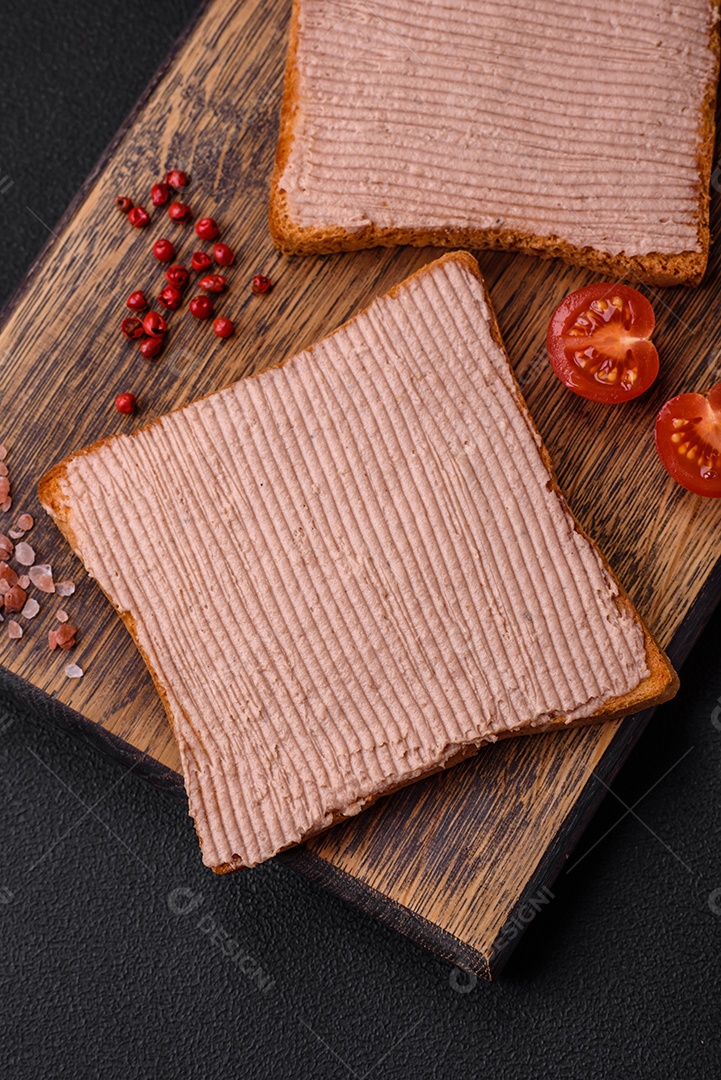 Deliciosa torrada crocante com frango ou patê de ganso com sal e especiarias sobre um fundo escuro de concreto