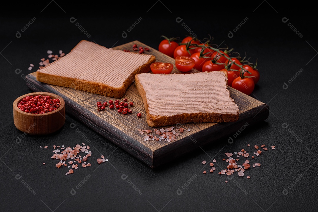 Deliciosa torrada crocante com frango ou patê de ganso com sal e especiarias sobre um fundo escuro de concreto