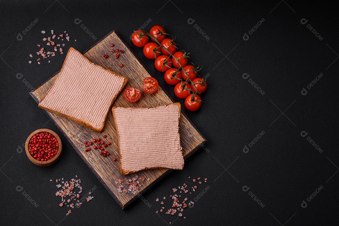 Deliciosa torrada crocante com frango ou patê de ganso com sal e especiarias sobre um fundo escuro de concreto