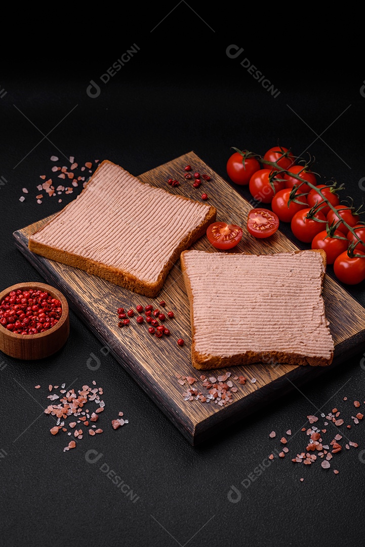 Deliciosa torrada crocante com frango ou patê de ganso com sal e especiarias sobre um fundo escuro de concreto