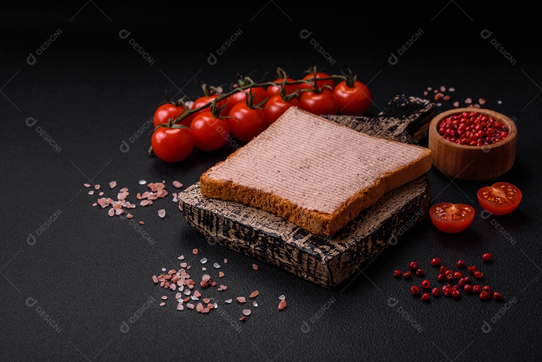 Deliciosa torrada crocante com frango ou patê de ganso com sal e especiarias sobre um fundo escuro de concreto