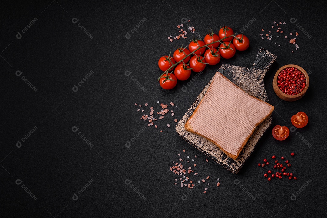 Deliciosa torrada crocante com frango ou patê de ganso com sal e especiarias sobre um fundo escuro de concreto