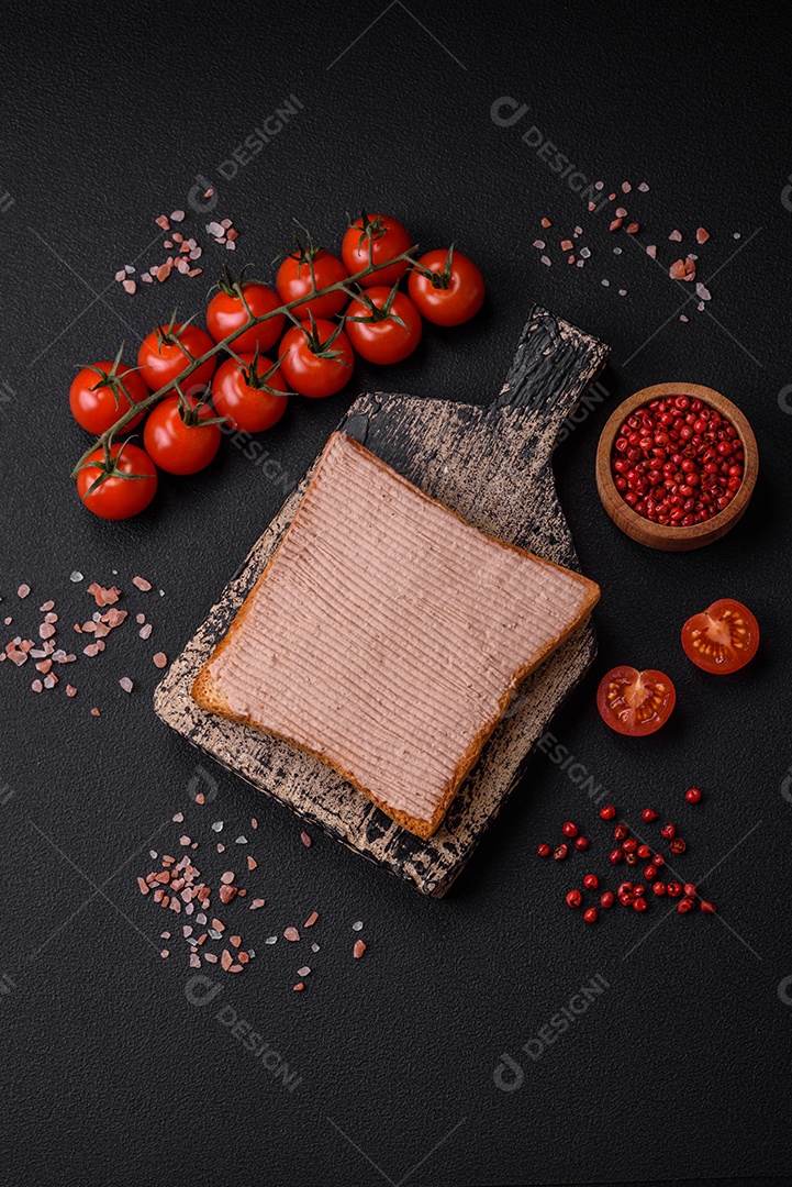 Deliciosa torrada crocante com frango ou patê de ganso com sal e especiarias sobre um fundo escuro de concreto