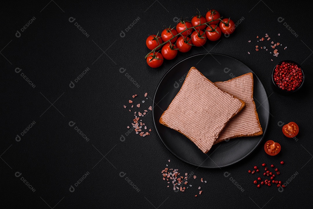 Deliciosa torrada crocante com frango ou patê de ganso com sal e especiarias sobre um fundo escuro de concreto