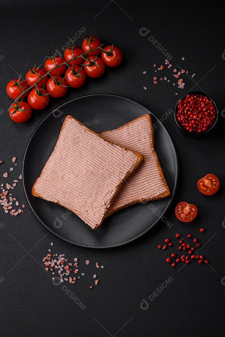Deliciosa torrada crocante com frango ou patê de ganso com sal e especiarias sobre um fundo escuro de concreto