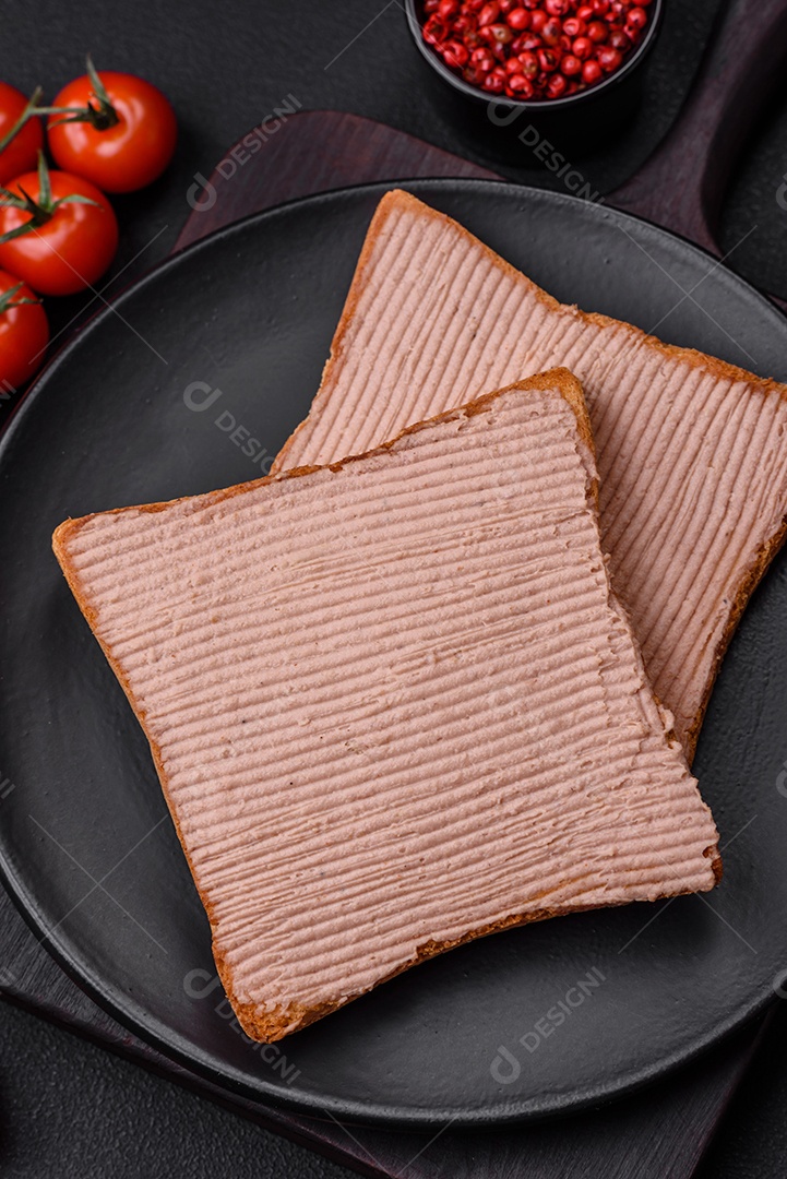Deliciosa torrada crocante com frango ou patê de ganso com sal e especiarias sobre um fundo escuro de concreto
