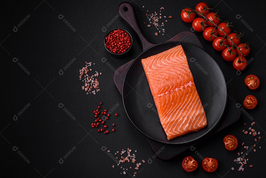 Filé de peixe vermelho salmão cru fresco com sal e especiarias sobre um fundo escuro de concreto