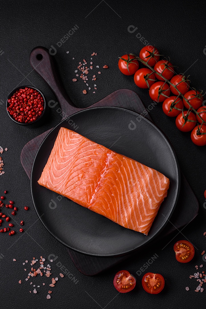 Filé de peixe vermelho salmão cru fresco com sal e especiarias sobre um fundo escuro de concreto