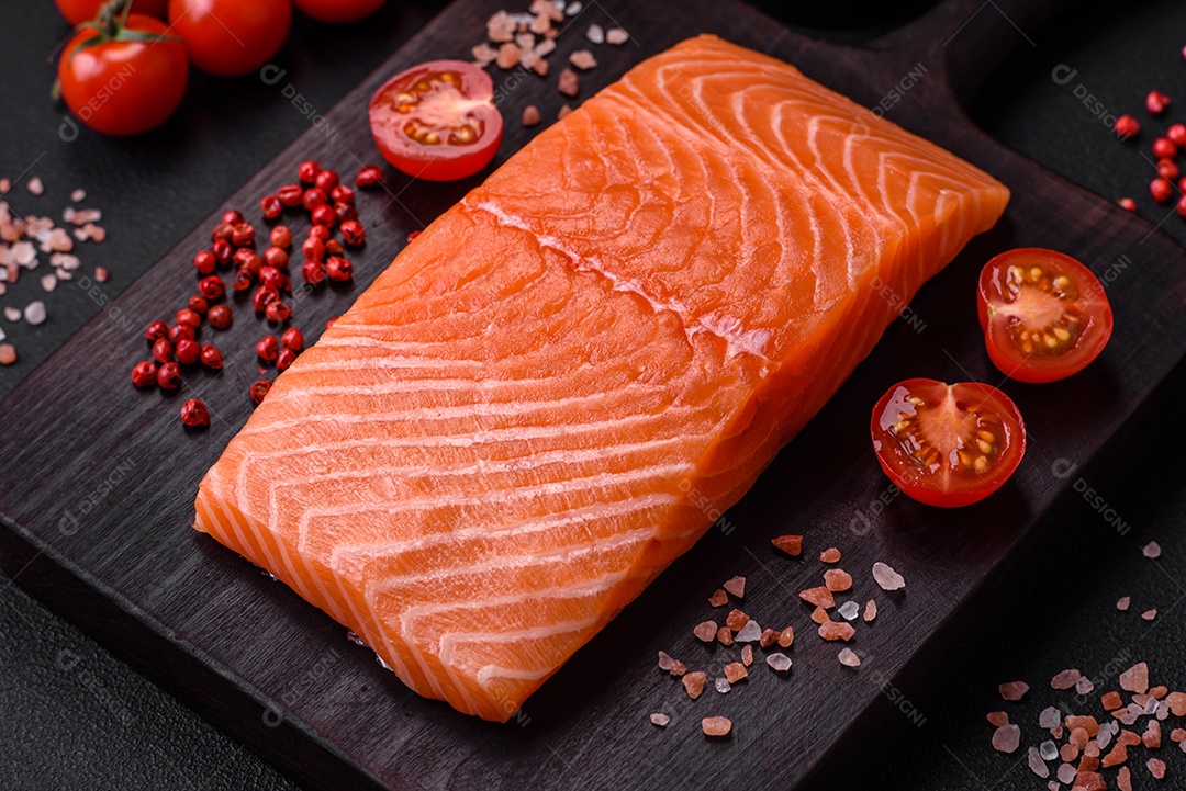 Filé de peixe vermelho salmão cru fresco com sal e especiarias sobre um fundo escuro de concreto