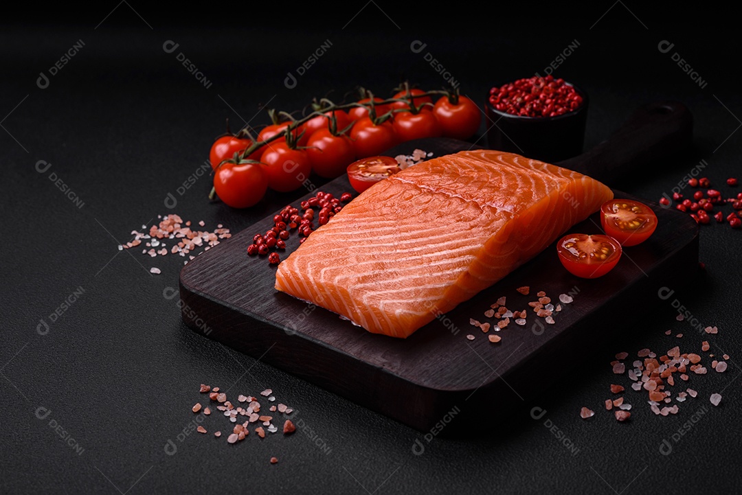 Filé de peixe vermelho salmão cru fresco com sal e especiarias sobre um fundo escuro de concreto