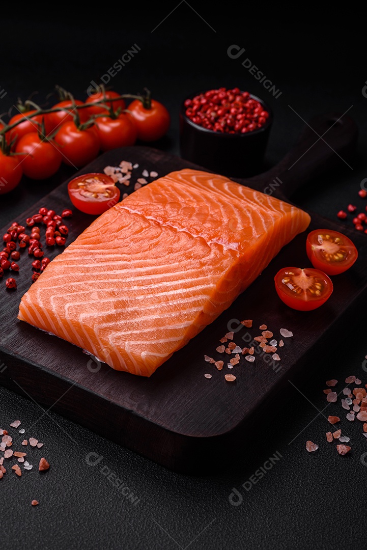Filé de peixe vermelho salmão cru fresco com sal e especiarias sobre um fundo escuro de concreto