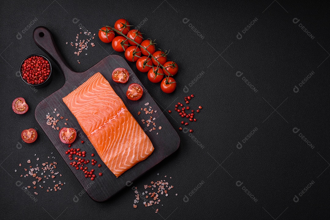 Filé de peixe vermelho salmão cru fresco com sal e especiarias sobre um fundo escuro de concreto